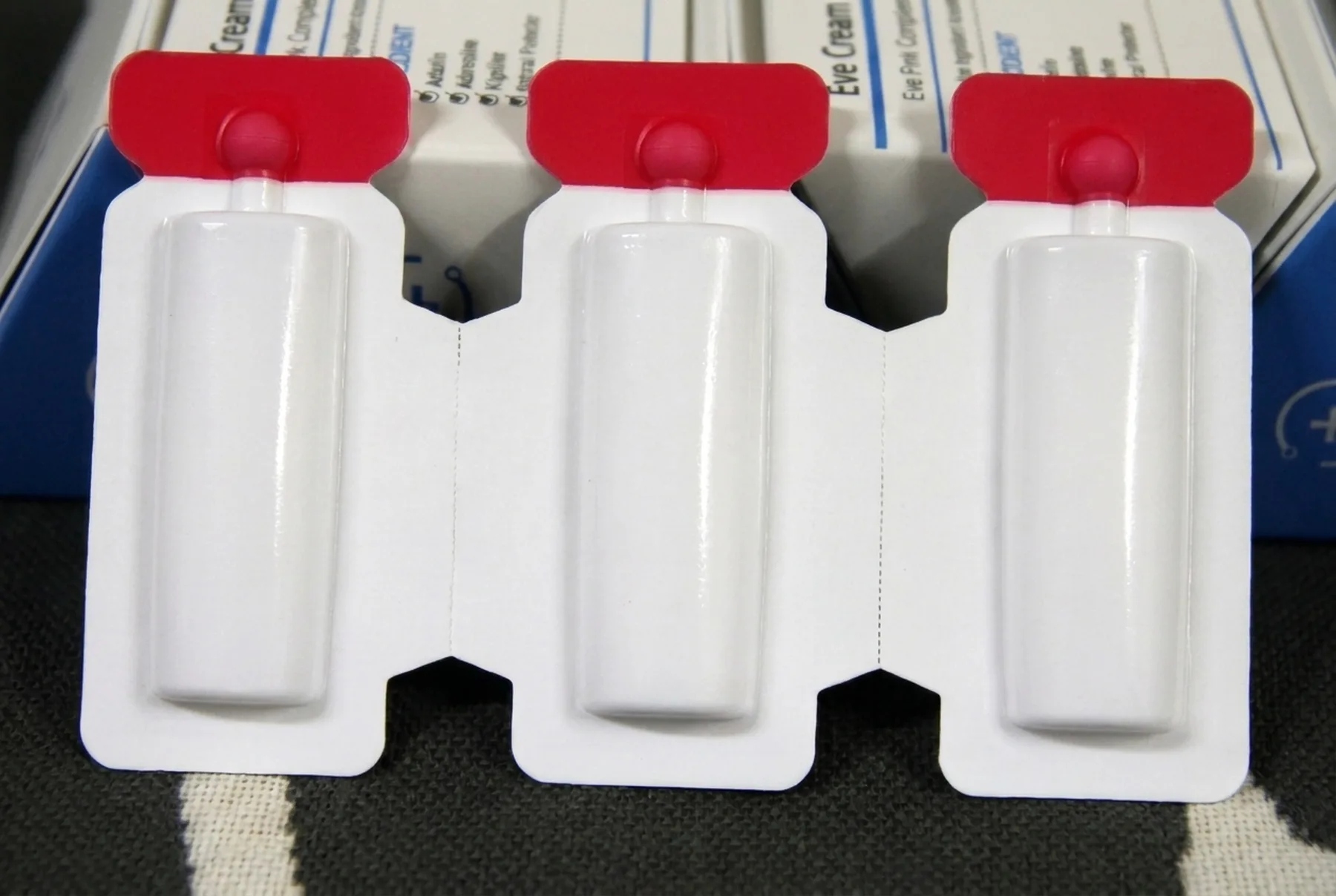 A strip of three unprinted blister packs, each holding a single dose