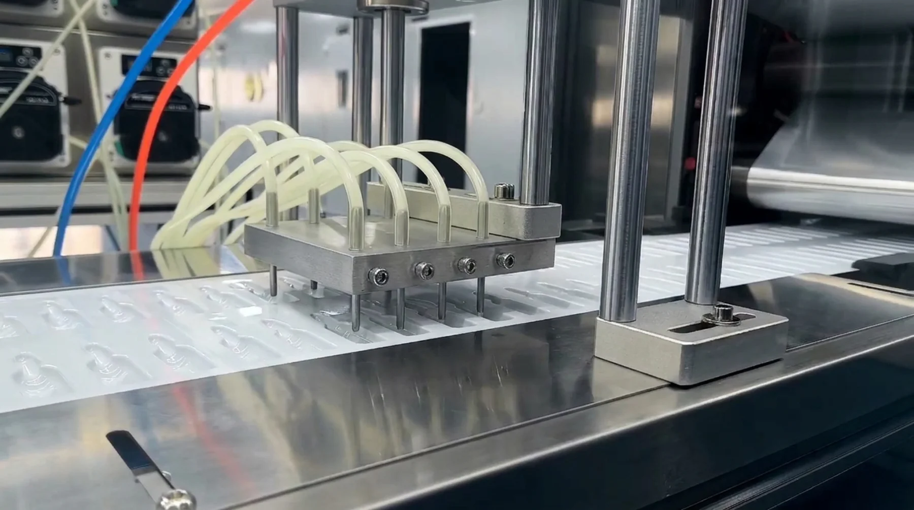 Stainless dosing nozzles above a web of open film cavities