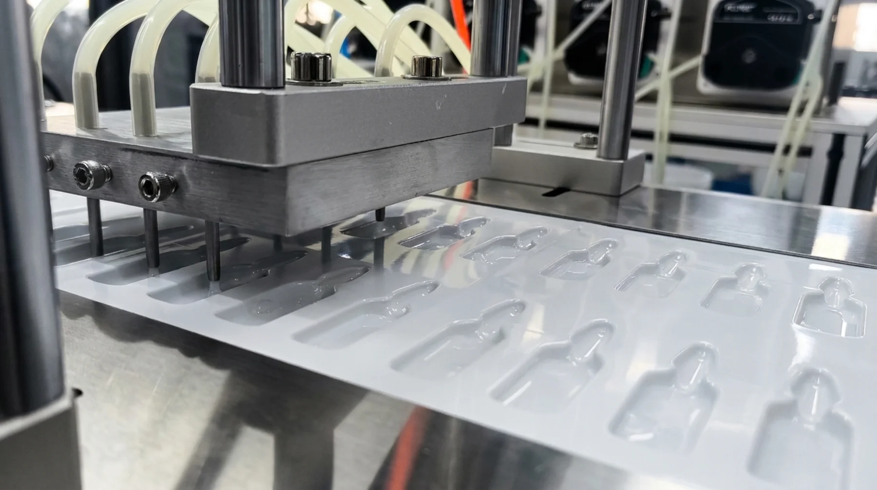 The forming tool descending onto the film web on the line
