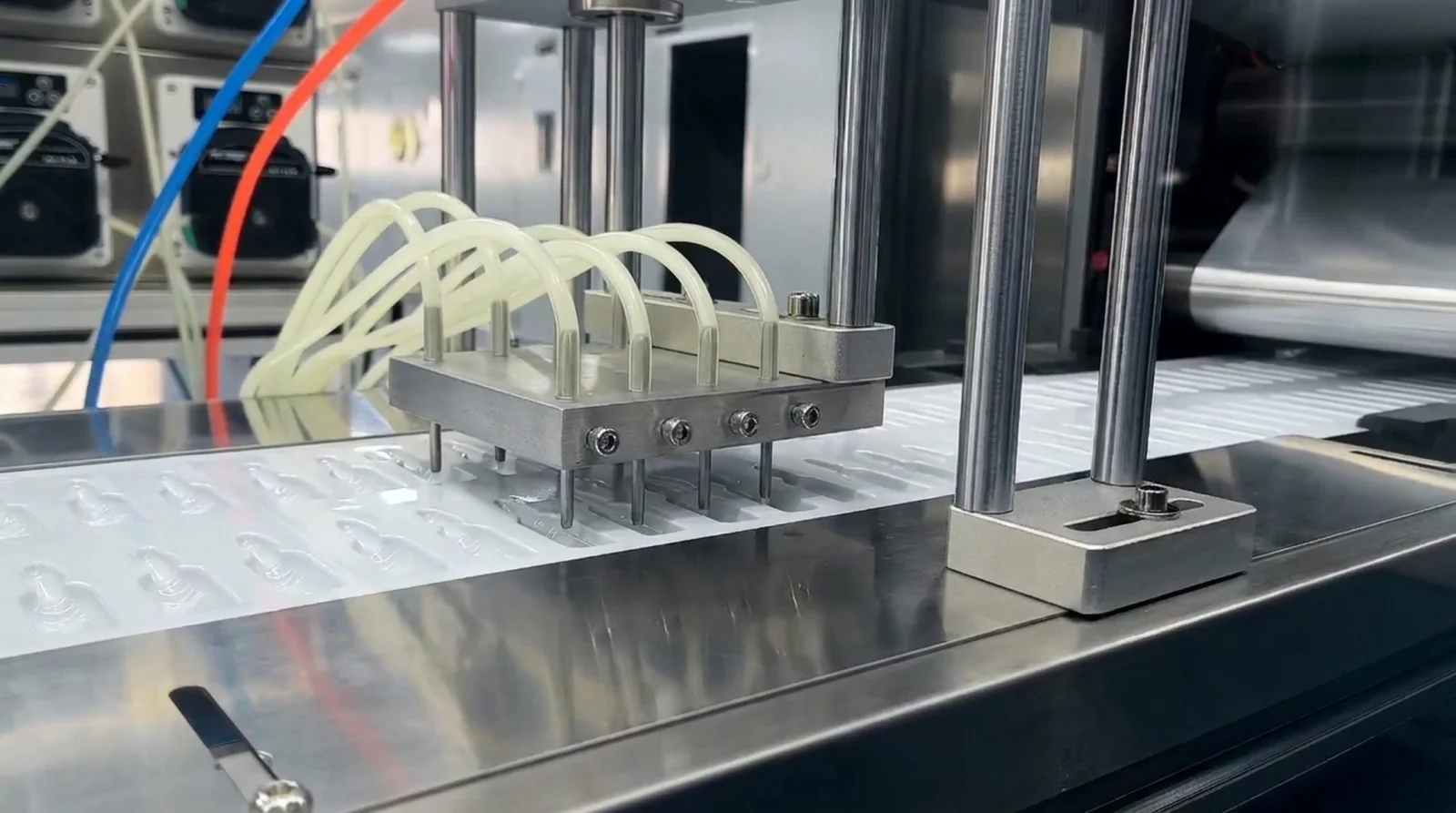 Stainless dosing nozzles positioned above open film cavities on the line